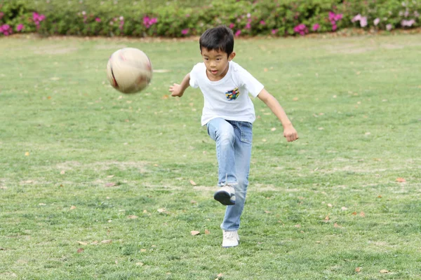 Japonský kluk hraje s fotbalovým míčem (třetí třídy na základní škole) — Stock fotografie