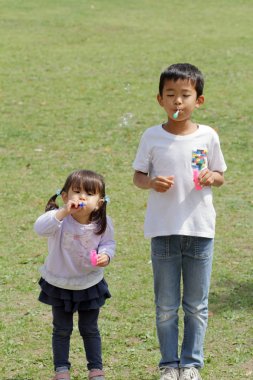 Japon ve kabarcık (8 yaşında çocuk ve 3 yıl yaşlı kız ile oynayan kız)