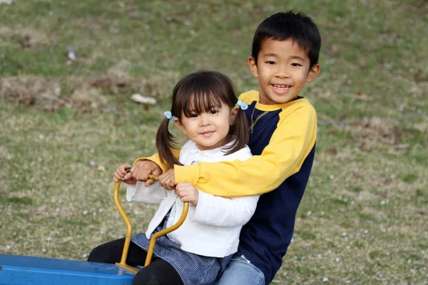 Japonský bratr a sestra na houpačce (8 let a 3 roky stará dívka) — Stock fotografie