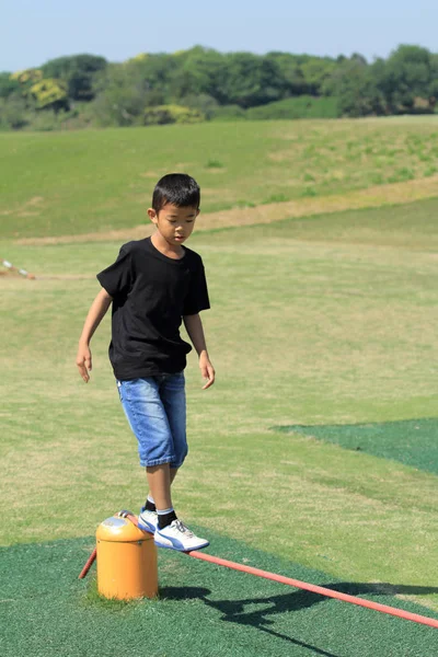 Japanischer Junge auf dem Schwebebalken (3. Klasse Grundschule)) — Stockfoto