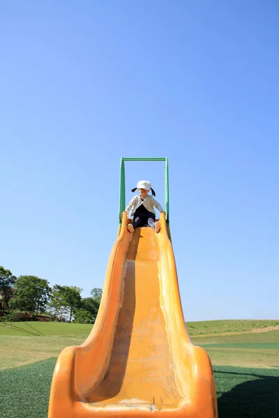 Japanisches Mädchen auf der Rutsche (3 Jahre alt)) — Stockfoto