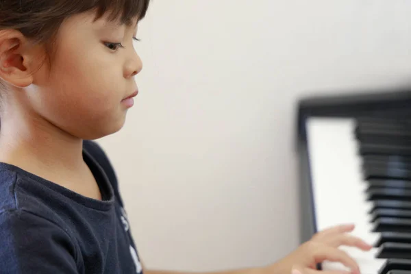 Japanisches Mädchen spielt Klavier (4 Jahre alt)) — Stockfoto