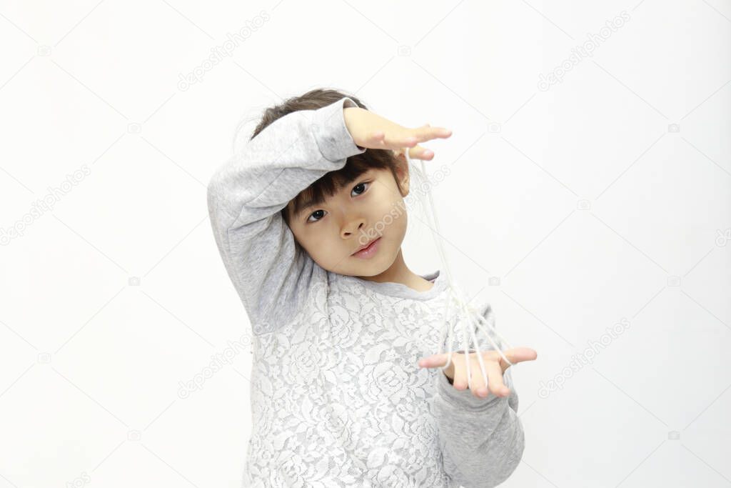 Japanese girl playing with cat's cradle (white back) (5 years old)
