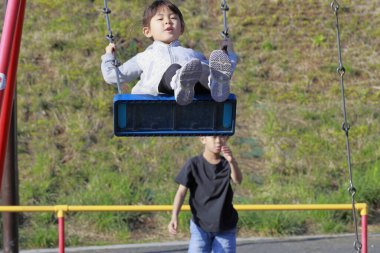 Japon kız kardeş salıncakta ve erkek kardeş onu itiyor (10 yaşında oğlan ve 5 yaşında kız çocuğu))