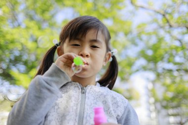 Japon kız yeşil baloncukla oynuyor (5 yaşında))