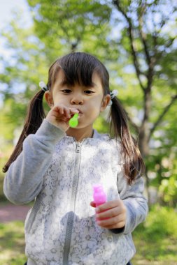 Japon kız yeşil baloncukla oynuyor (5 yaşında))