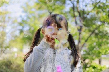 Japon kız yeşil baloncukla oynuyor (5 yaşında))
