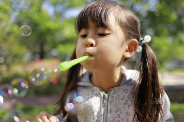 Japon kız yeşil baloncukla oynuyor (5 yaşında))