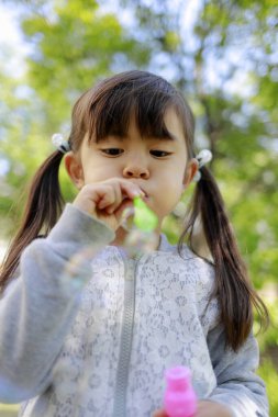 Japon kız yeşil baloncukla oynuyor (5 yaşında))