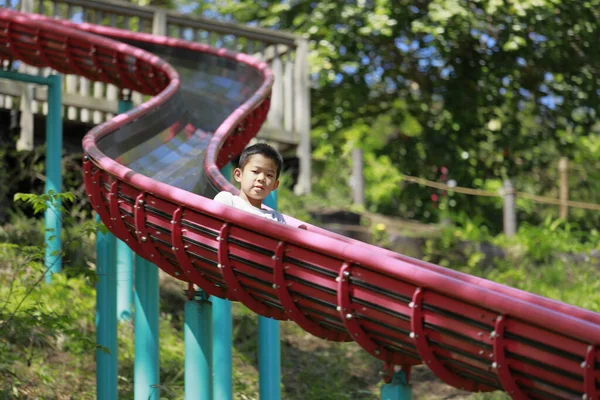 滑り台に立つ日本人少年 小学校5年生 — ストック写真