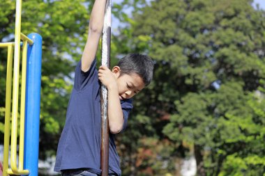 Japon çocuk tırmanma direğiyle oynuyor (ilkokulda beşinci sınıf)