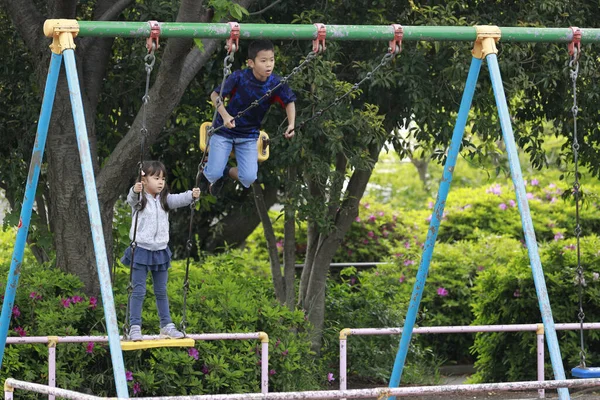 スイングの日本人の弟と妹 10歳の男の子と5歳の女の子 — ストック写真