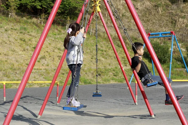 スイングの日本人の弟と妹 10歳の男の子と5歳の女の子 — ストック写真