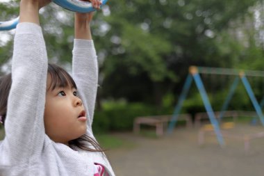 Japon kız maymun parmaklıklarıyla oynuyor (5 yaşında))