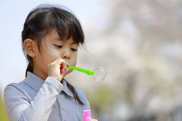 青い空の下で泡と遊ぶ日本人の女の子 — ストック写真