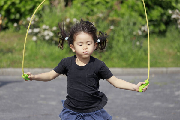 Японская девочка (5 лет), играющая с прыжком
