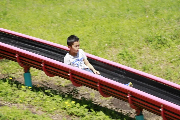 滑り台に立つ日本人少年 小学校5年生 — ストック写真