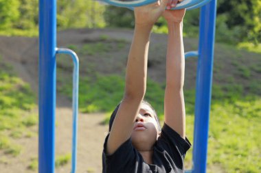 Japon çocuk maymun parmaklıklarıyla oynuyor (ilkokulda beşinci sınıf)