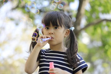 Japon kız yeşil baloncukla oynuyor (5 yaşında))