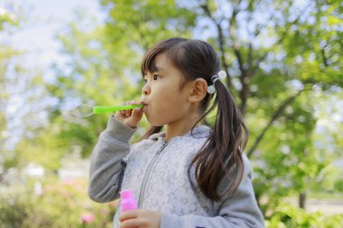 Japon kız yeşil baloncukla oynuyor (5 yaşında))