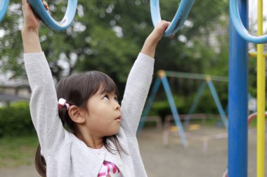 Japon kız maymun parmaklıklarıyla oynuyor (5 yaşında))