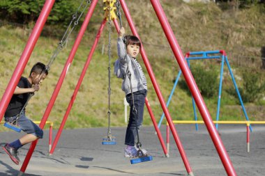 Japon erkek ve kız kardeş salıncakta (10 yaşında oğlan ve 5 yaşında kız))
