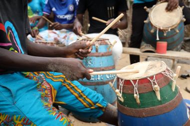 Close-up of a musician playing traditional drums on the beach in Accra, Ghana clipart