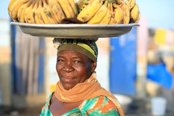 Kvinna bär plattan med bananer — Stockfoto