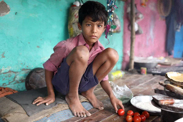 Уличный ребенок готовит еду в трущобах в Калькутте, Индия — стоковое фото