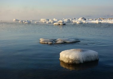 Winter scene with snow covered rocks by the Baltic sea in Helsinki, Finland  clipart