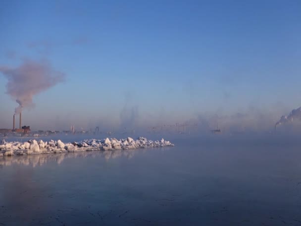 Снег покрыл скалы у Балтийского моря чрезвычайно холодным зимним утром с густым морским дымом на заднем плане — стоковое видео
