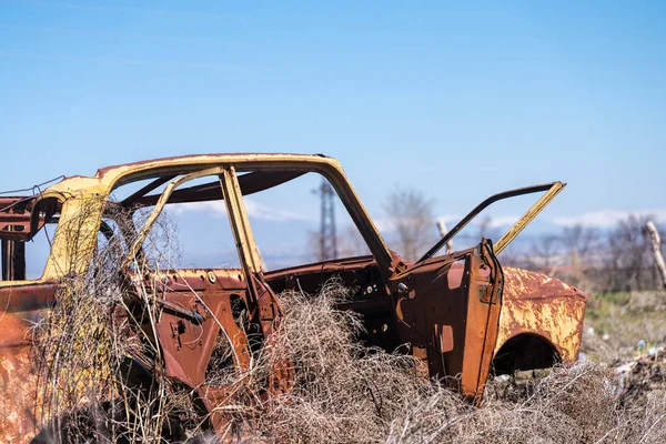 Verlaten wrak van een gele Sovjet-Russische auto in het midden van de droge hooi in zuidelijke Armenië — Stockfoto