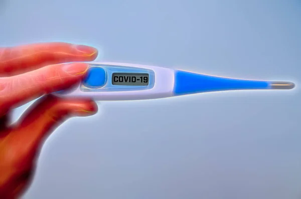 在全球Covid 19或Corona大流行期间 女性手拿着带有Covid 19文字的临床温度计在屏幕上观看 — 图库照片