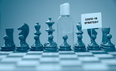 Coronavirus konsepti resim satranç taşları ve el dezenfektanı, covid-19 strateji işaretli yeni covid-19 salgınına karşı küresel mücadeleyi gösteriyor.. 