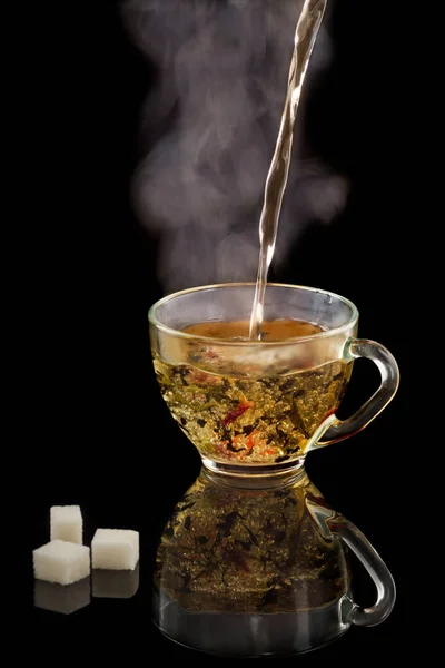 黒の背景に蒸気で熱いお茶のカップ — ストック写真