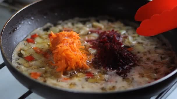 Hände Kochen gebratene Zwiebel mit Karotte in der Pfanne — Stockvideo