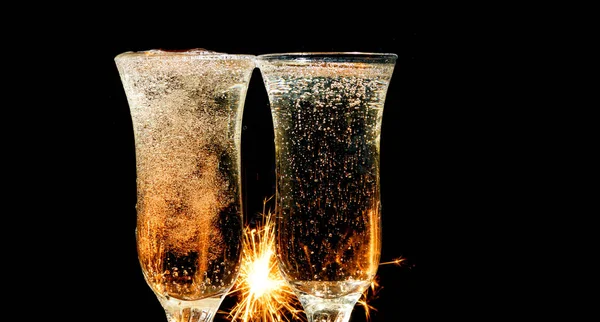 Glasses of champagne and sparklers on bright background with — Stock Photo, Image