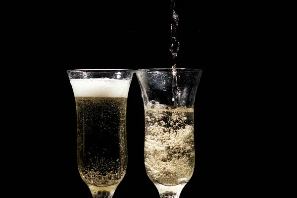 Bicchiere di champagne con spruzzi, isolato su sfondo nero — Foto Stock