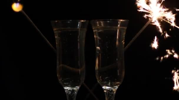 Ποτήρια της σαμπάνιας και βεγγαλικά σε φωτεινό φόντο με — Αρχείο Βίντεο
