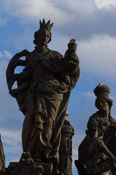 Socha St.Margarita a St. Elisabeth na Karlově mostě v Praze. Pestré jarní ráno v hlavním městě České republiky, Evropa. — Stock fotografie