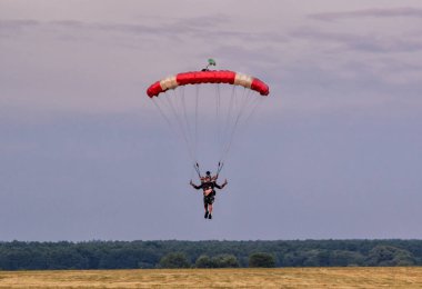 Sutiski, Ukrayna - 24 Haziran 2017: Skydivers iniş sonra bir paraşüt taşır. Skydive Ukrayna olduğunu Sutiski Aerodrome yaklaşık 20 km Vinitsa, Ukrayna'nın güneybatısında bulunan havadalışı Merkezi.