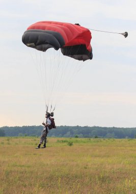 Sutiski, Ukrayna - 24 Haziran 2017: Skydivers iniş sonra bir paraşüt taşır. Skydive Ukrayna olduğunu Sutiski Aerodrome yaklaşık 20 km Vinitsa, Ukrayna'nın güneybatısında bulunan havadalışı Merkezi.