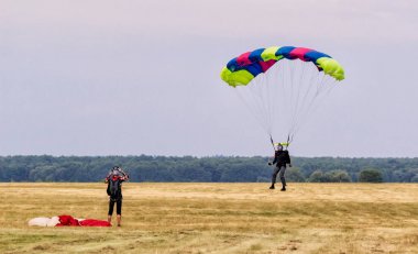 Sutiski, Ukrayna - 24 Haziran 2017: Skydivers iniş sonra bir paraşüt taşır. Skydive Ukrayna olduğunu Sutiski Aerodrome yaklaşık 20 km Vinitsa, Ukrayna'nın güneybatısında bulunan havadalışı Merkezi.