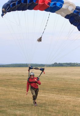 Sutiski, Ukrayna - 24 Haziran 2017: Skydivers iniş sonra bir paraşüt taşır. Skydive Ukrayna olduğunu Sutiski Aerodrome yaklaşık 20 km Vinitsa, Ukrayna'nın güneybatısında bulunan havadalışı Merkezi.