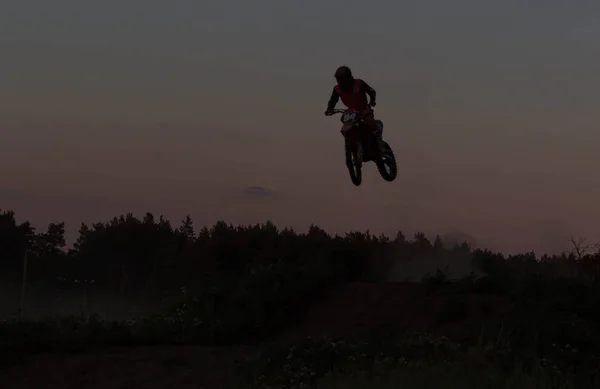 Silhouette floue de motocross sautant sur la montagne au coucher du soleil — Photo