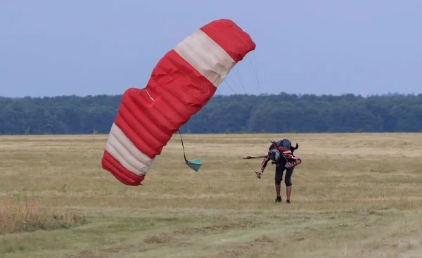 Sutiski, Ucrânia - 24 de junho de 2017: Skydivers carrega um paraquedas após o desembarque. Skydive Ucrânia é o centro de paraquedismo localizado no aeródromo de Sutiski, cerca de 20 km a sudoeste de Vinitsa, Ucrânia . — Fotografia de Stock