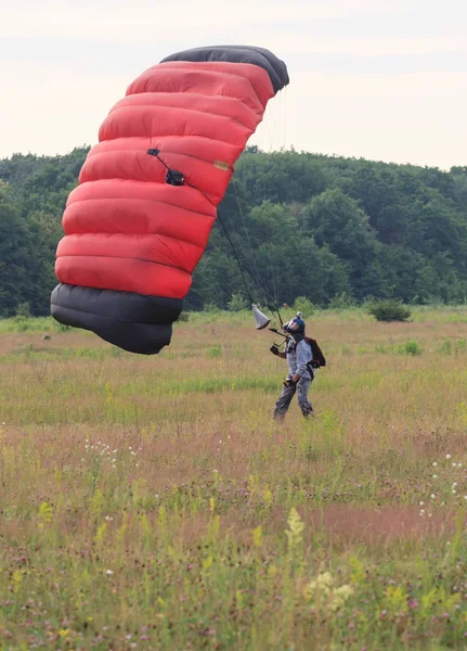 Sutiski, Ukraine - June 24, 2017: Skydivers carries a parachute after landing. Skydive Ukraine is the skydiving center located at Sutiski Aerodrome, about 20 km southwest of Vinitsa, Ukraine. — Stock Photo, Image