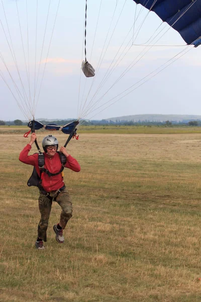 Sutiski, Ukrayna - 24 Haziran 2017: Skydivers iniş sonra bir paraşüt taşır. Skydive Ukrayna olduğunu Sutiski Aerodrome yaklaşık 20 km Vinitsa, Ukrayna'nın güneybatısında bulunan havadalışı Merkezi.