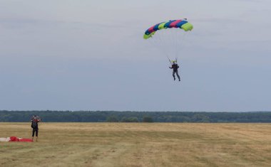Sutiski, Ukrayna - 24 Haziran 2017: Skydivers iniş sonra bir paraşüt taşır. Skydive Ukrayna olduğunu Sutiski Aerodrome yaklaşık 20 km Vinitsa, Ukrayna'nın güneybatısında bulunan havadalışı Merkezi.