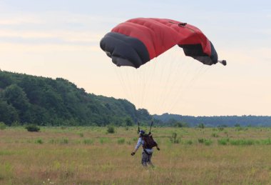Sutiski, Ukrayna - 24 Haziran 2017: Skydivers iniş sonra bir paraşüt taşır. Skydive Ukrayna olduğunu Sutiski Aerodrome yaklaşık 20 km Vinitsa, Ukrayna'nın güneybatısında bulunan havadalışı Merkezi.